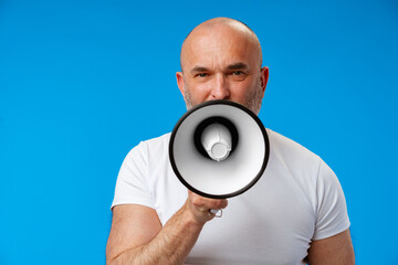 Middle-aged man speakng into megaphone against blue background