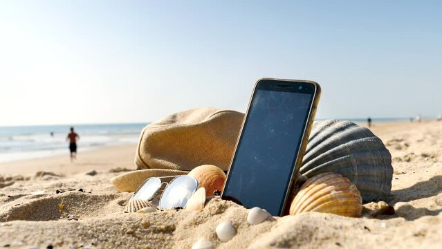mobile phone on the beach with hat and sunglasses