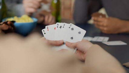 Cheerful people enjoying card game with tactics and dice, playing board games together with...