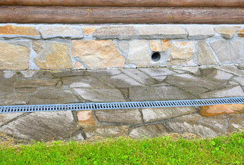 A fragment of a basement with a blind area of a country house on a summer day