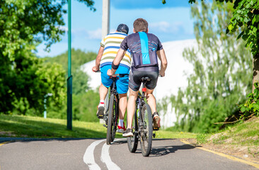 Fototapeta premium Cyclists ride on the bike path in the city Park 