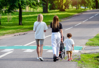 Mother wheeling a pram in the Park
