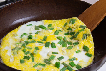 Egg with green onions fried in a pan