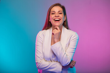 Emotional business woman with open mouth, portrait with neon lights colors effect. Female model on neon colored background wearing white suit.