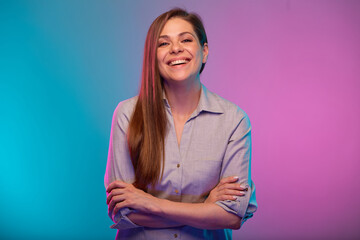 Smiling woman with arms crossed portrait in neon lights. Businesswoman isolated on neon multicolored background.