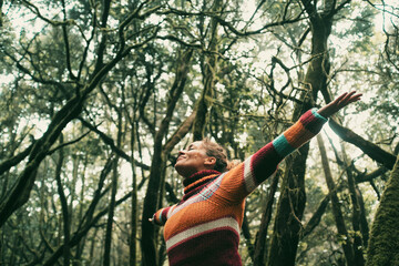 Happy adult woman smile and open arms to embrace beautiful nature forest around her. Concept of...