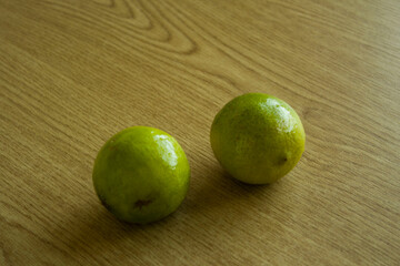 Two limes on a wooden table. Food photography.
