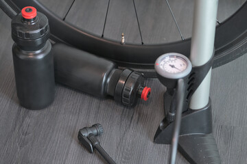 water bottles for cycling , pump for bicycle with manometer and carbon bike wheel concept on black...