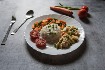 White rice and continental chicken along with condiments served in a plate on a background. Top view, selective focus.