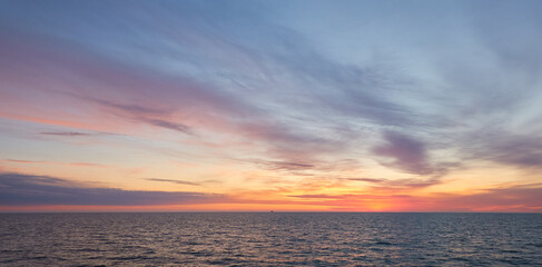 Baltic sea at sunset. Dramatic sky, blue and pink glowing clouds, soft golden sunlight, midnight...
