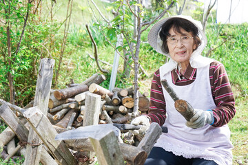 Elderly woman chopping firewood