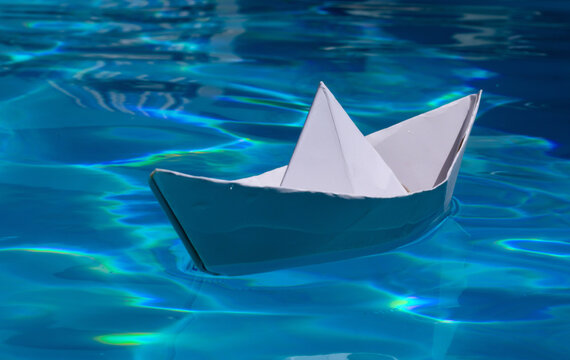 Paper ship. Paper boat in blue sea background. Tourism, travel dreams vacation holiday. Paper craft and origami.