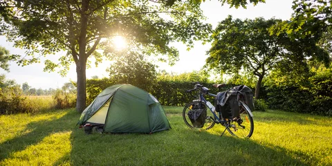 Gordijnen Kampeerplek tijdens een bikepacking-tour bij zonsondergang © photoschmidt