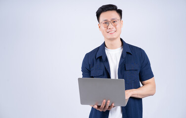 Young Asian man using laptop on white background