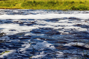 river water flowing in summer with foam and waves