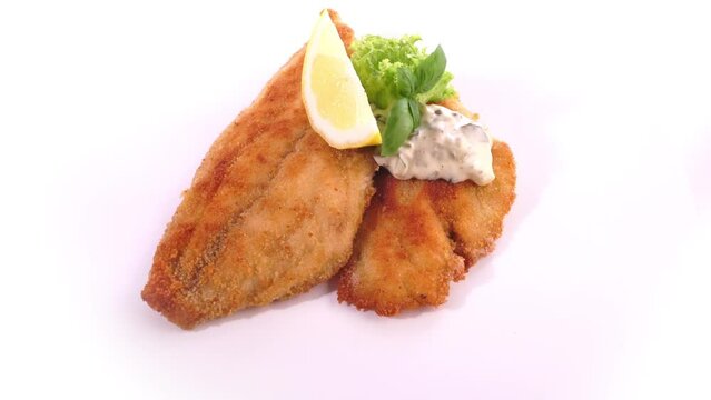 Fried Fish Fillet with Sauce Remoulade and Lemon - Food on a turntable isolated on white background