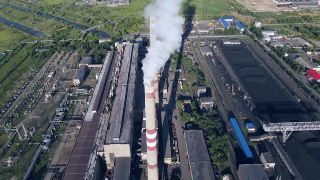 Smoky chimneys of the power plant aerial view.Electric power generation,power plant for burning coal.Thick smoke from burning fuel.Atmospheric pollution,harmful emissions and global warming,ecological