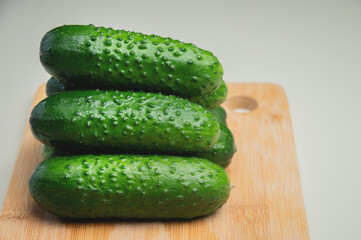 Fresh cucumbers on a wooden cutting board. Vegetables on the kitchen table