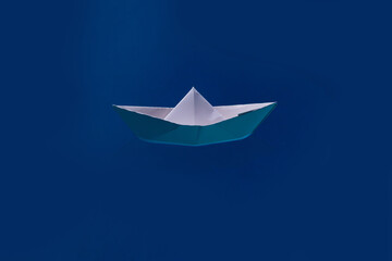 Paper boat sailing on blue water surface. Paper ship. Paper boat in blue sea background. Tourism, travel dreams vacation holiday.
