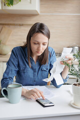 woman pays utility bills and writes checks. a European woman at home makes a calculation of...