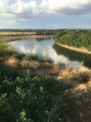 Fototapeta na wymiar River among summer greenery. Summer river in greenery outdoors. River in summer. Summer river landscape