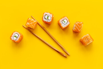 Salmon sushi rolls set with chopsticks on table, top view