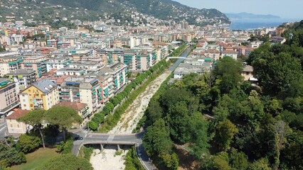 Fototapeta na wymiar Drone aerial view of a small river bed completely without water goes towards the sea - emergency drought and aridity in Rapallo Liguria - climate change and global warming 