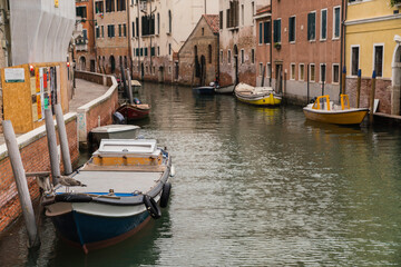 Fototapeta na wymiar boats docked on canal in Venice, Italy and colorful buildings 