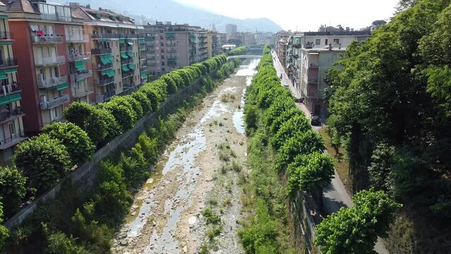 Italy , Rapallo , Genoa  Liguria - Drone aerial view of small river between the buildings completely without water due to drought and aridity - at the mouth the salt water of the sea goes up the river