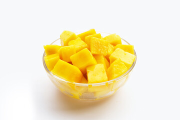 Yellow mango clube slices in glass bowl on white background.