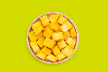 Yellow mango cube slices on green background.