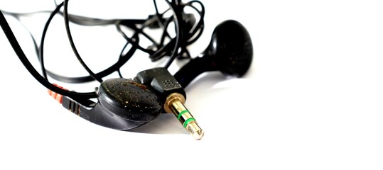 used black headphone. dirty black earphone isolated. earbuds with 3.5mm jack