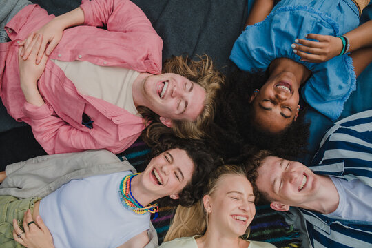 Top view of diverse group of friends having fun together at park lauging and lying on ground, Friendship and lifestyle concepts