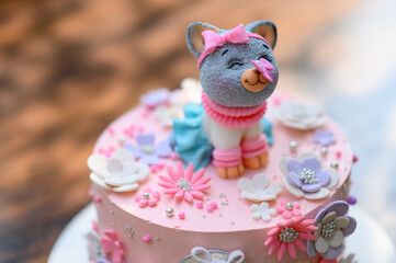 Festive pink cake with a cat on top.