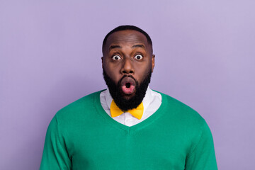 Portrait of attractive young man with bow tie see his reflection after barber treatment isolated on violet color background