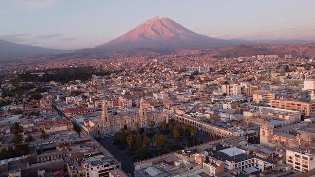 Arequipa, Peru: Aerial drone footage of the famous Plaza de Armas in Arequipa colonial old town with the Basilica Cathedral and the Misti and the  Pichu Pichu  volcanoes  at sunset in the Andes. 