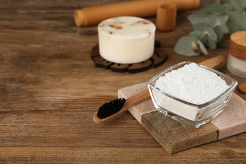 Tooth powder and brush on wooden table, space for text