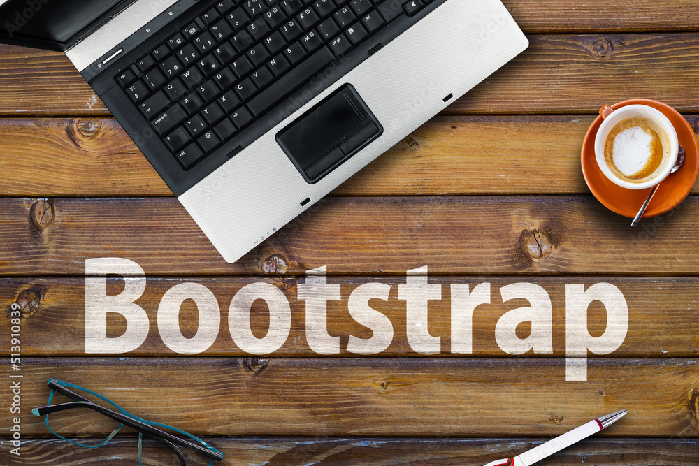 Poster bootstrap css framework . word bootstrap on wooden desk and laptop
