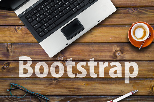 Bootstrap CSS framework . Word Bootstrap on wooden desk and laptop
