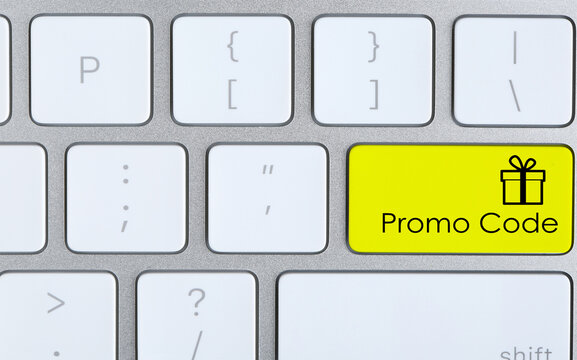 Yellow button with phrase Promo Code and image of gift box on computer keyboard, top view
