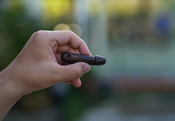 small Wooden image of penis in hand boy and amulet of thailand