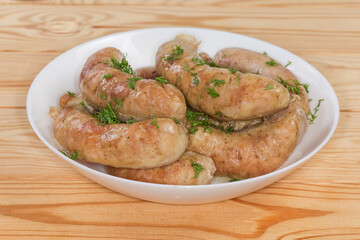 Baked chicken sausages in bowl, close-up in selective focus