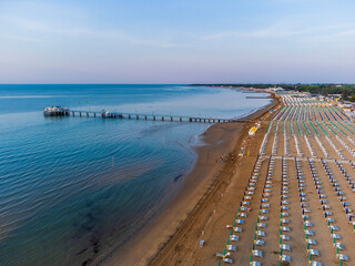 Fototapeta premium Sunrise in Lignano Sabbiadoro seen from above. From the sea to the lagoon, the city of holidays
