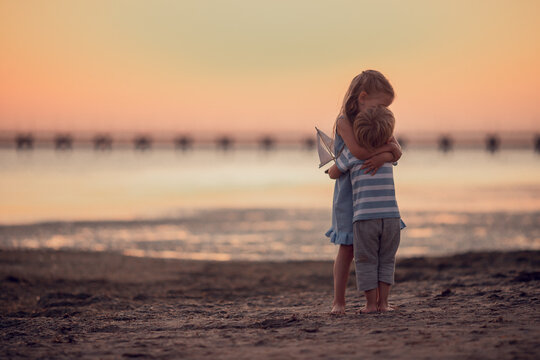 brother and sister love each other, little boy and girl hugs on the seashore on journey. beautiful sunset. Traveling with children, dreams, vacation, friendly family and leisure concept