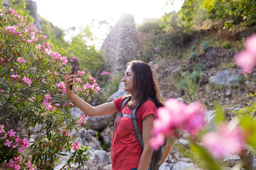 A woman takes a selfie against the background of a landmark, park with oleander flowers