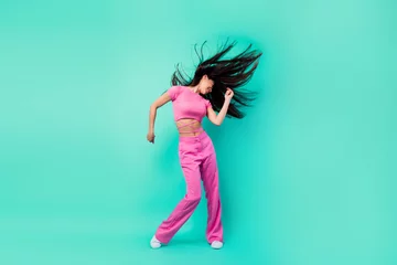Gordijnen Full body photo of crazy energetic of young lady express herself on dancing floor isolated on teal color background © deagreez