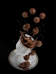 flying chocolates with white icing and soft chocolate filling, with a splash of liquid chocolate on a white dish on a black background