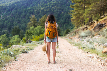 A woman with a backpack on a mountain path