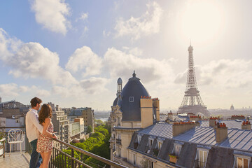Shot of a young couple admiring the view from the balcony of an apartment overlooking The Eiffel...