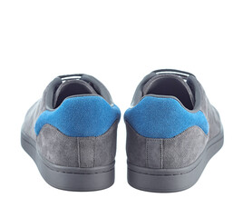 Beautiful pair of fashionable modern sneakers made of gray suede with inserts of bright blue suede in the back, lace-up, isolated on a white background. Rear view.